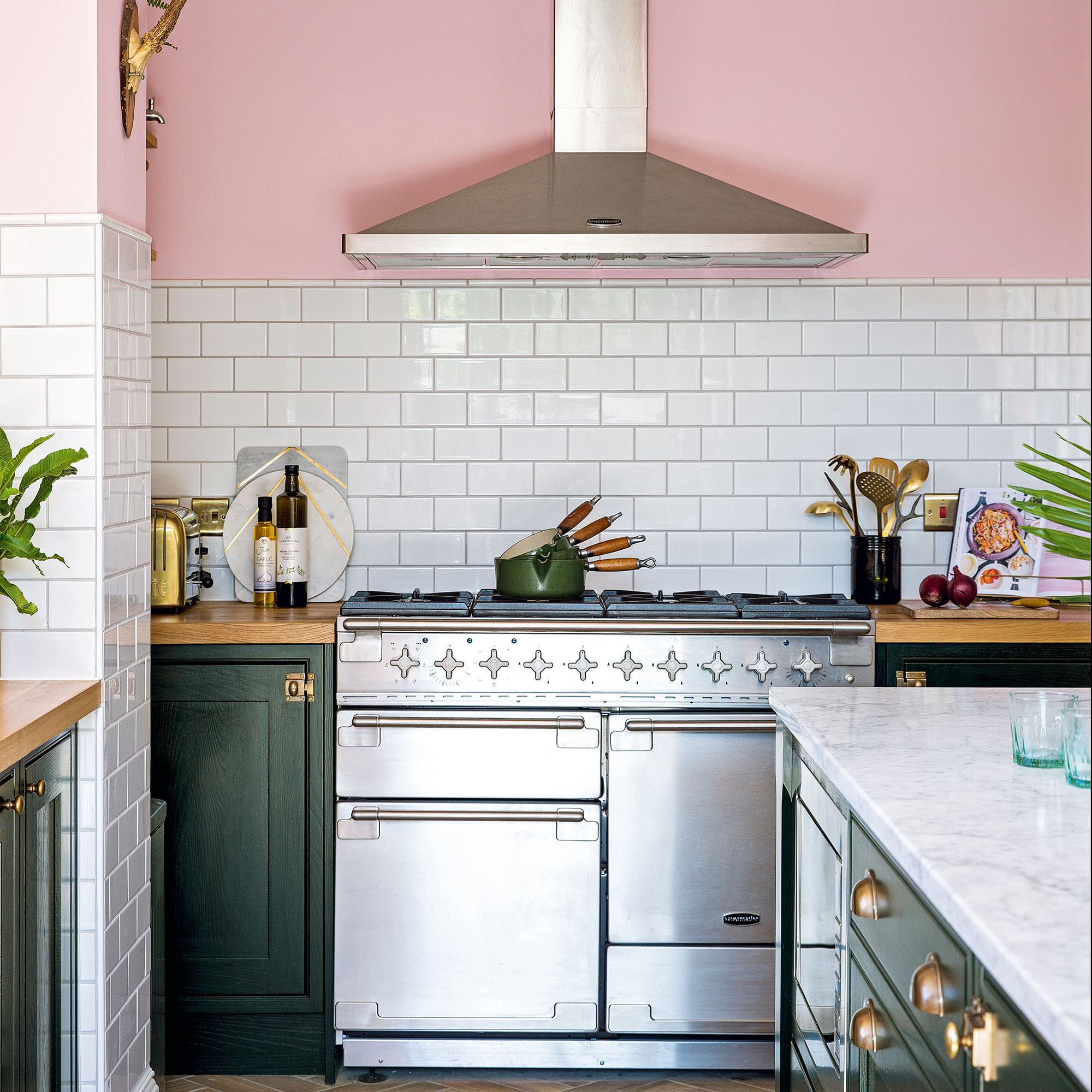 Pink kitchen with green cabinets and a silver range cooker