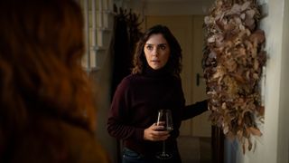 Annabel Scholey as Charlotte answers the door with a glass in her hand in The Couple Next Door Season 2