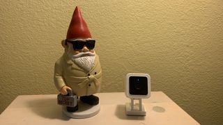 The Wyze Cam v3 next to a spy gnome with a briefcase that says "top secret"