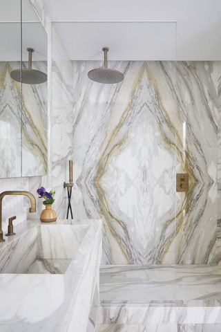 A natural marble bathroom with a walk in shower
