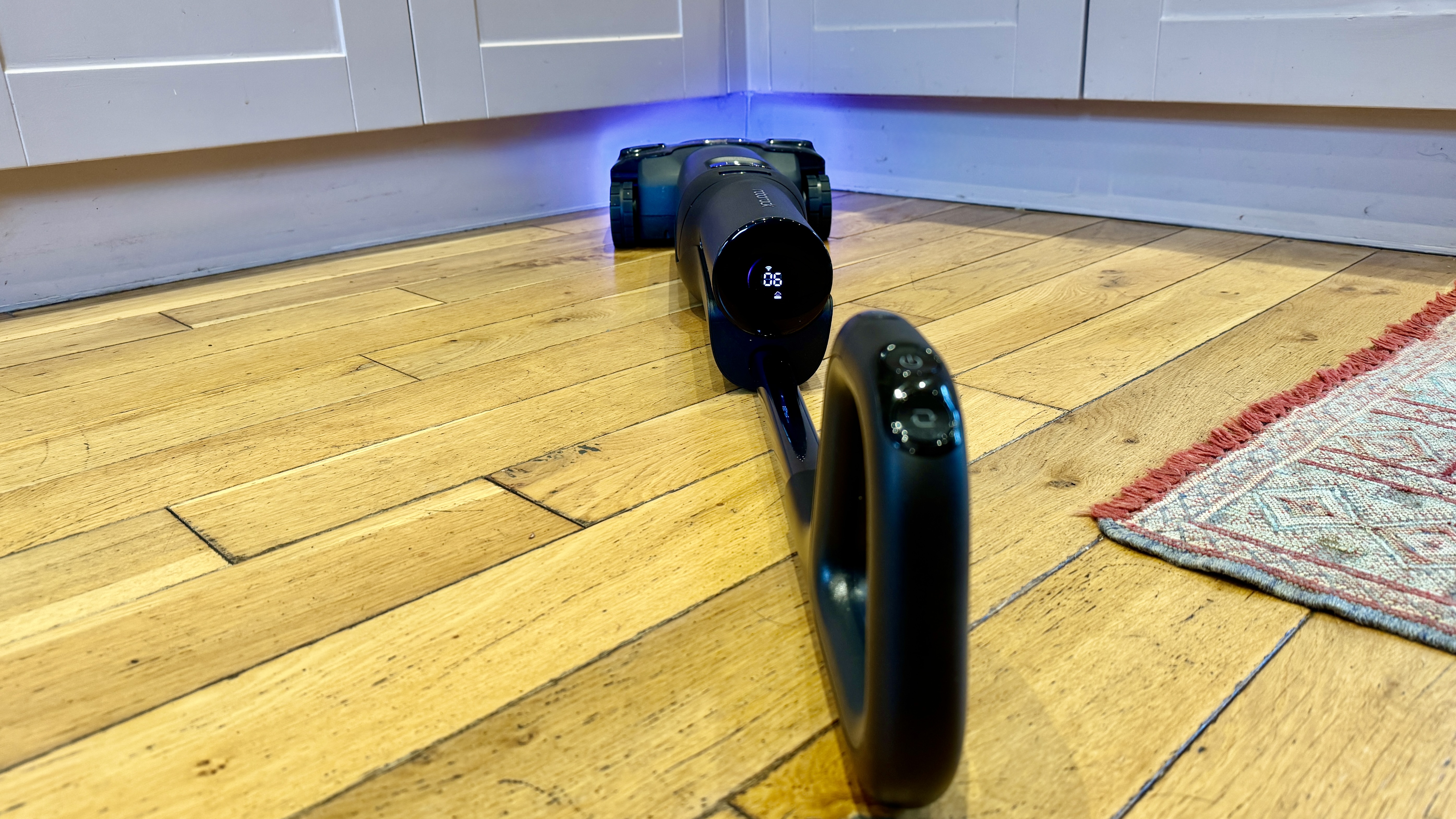 Roborock F25 Ultra lying flat on a wooden floor as it cleans