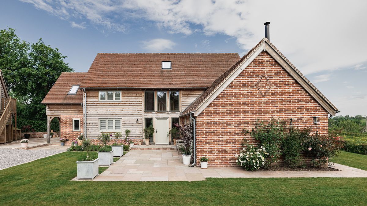 A large two storey oak frame home clad in timber and brick with a pitched roof