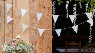 Decorating for a garden party with white bunting and natural foliage
