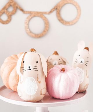 A pumpkin decorating idea using butternut squash and pumpkins to depict bunny rabbits with 'Boo' glitter bunting in background