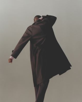 Male model walking away, wears coat and trousers