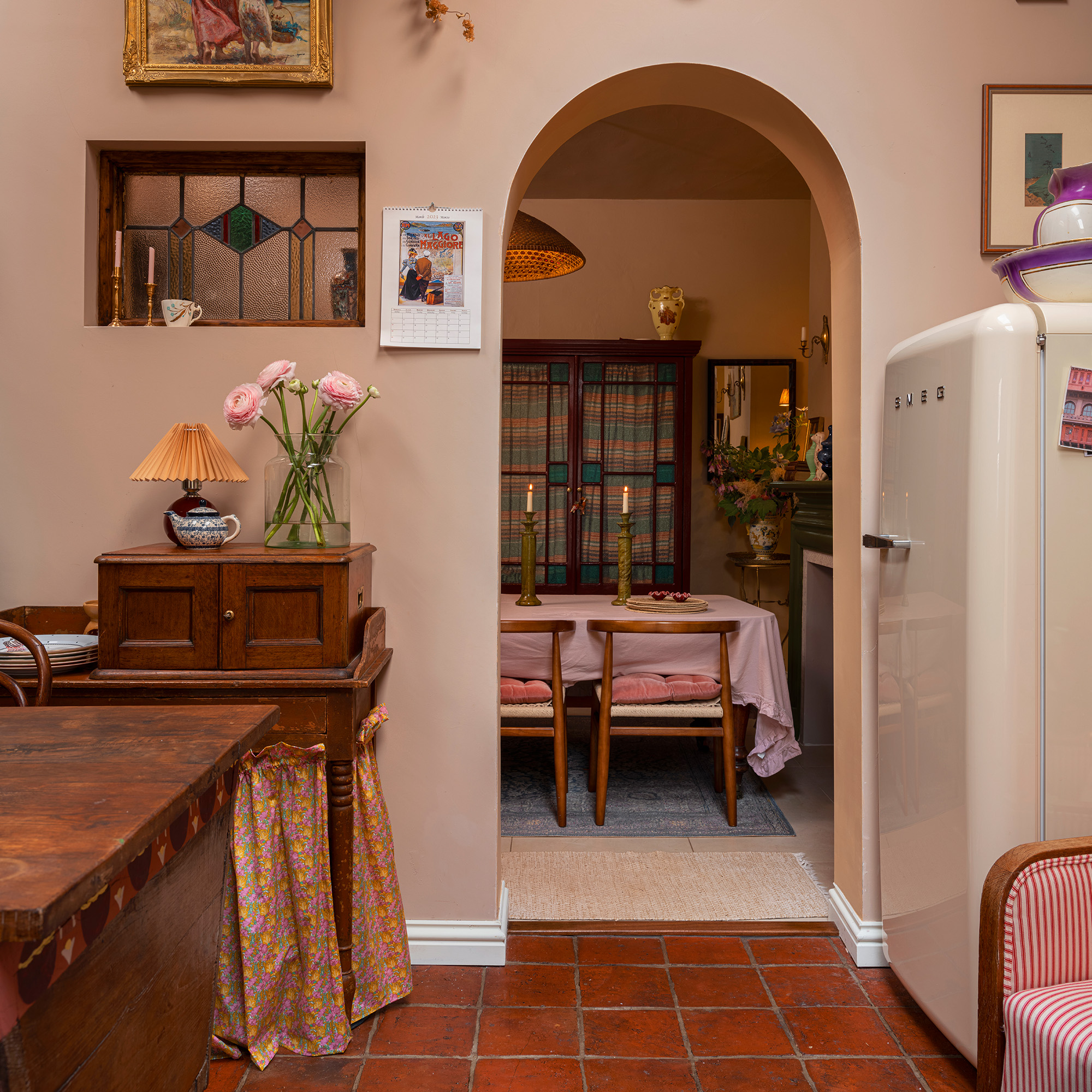 kitchen with view through arched doorway into dining room stained glass transom window and antique furniture