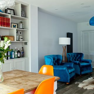 living area with white wall and blue two couches
