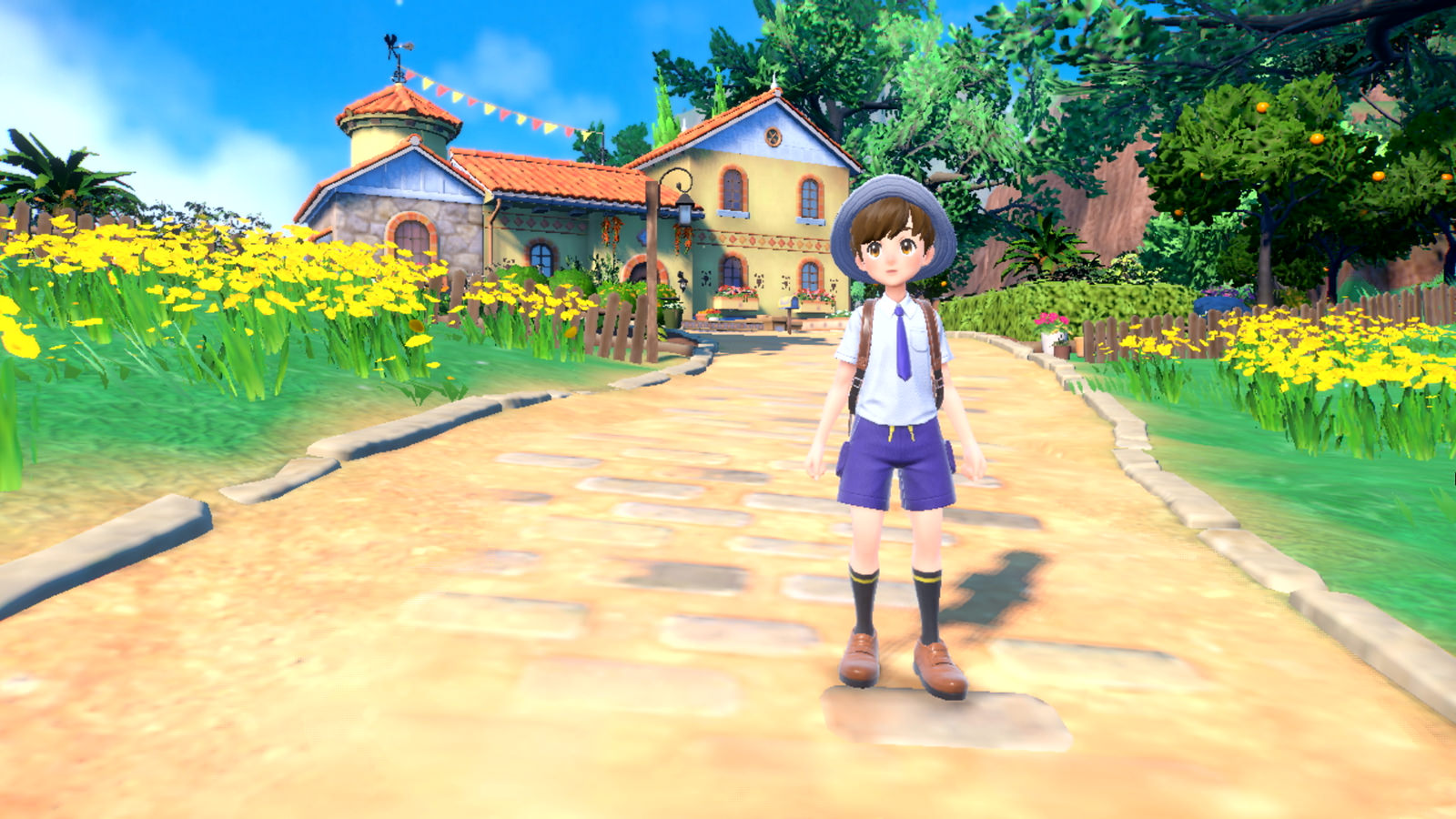 A young trainer stands on a path surrounded by flowers.