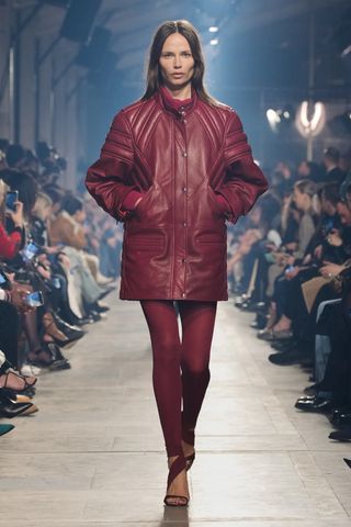 model wears red leggings with a red leather jacket in Isabel Marant fall winter 2023