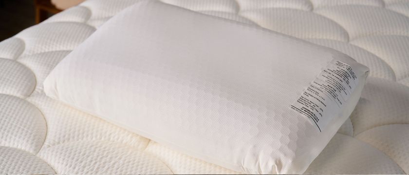 The image shows the white Purple GridCloud pillow placed on top of a on a white mattress 