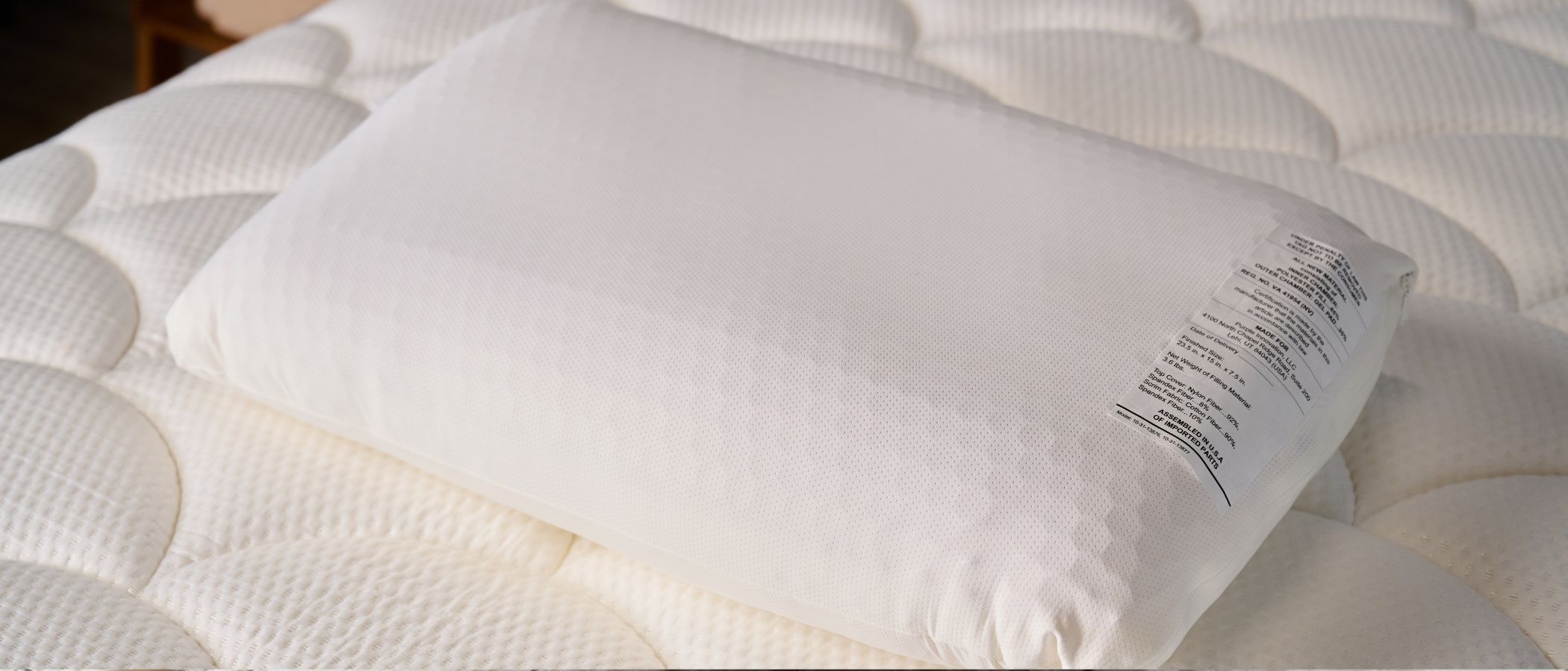 The image shows the white Purple GridCloud pillow placed on top of a on a white mattress
