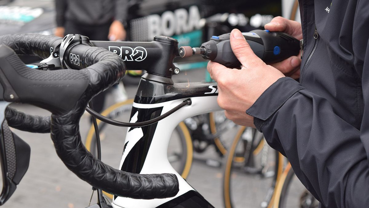 A Bora-Hansgrohe mechanic files down stem bolts the day before the race