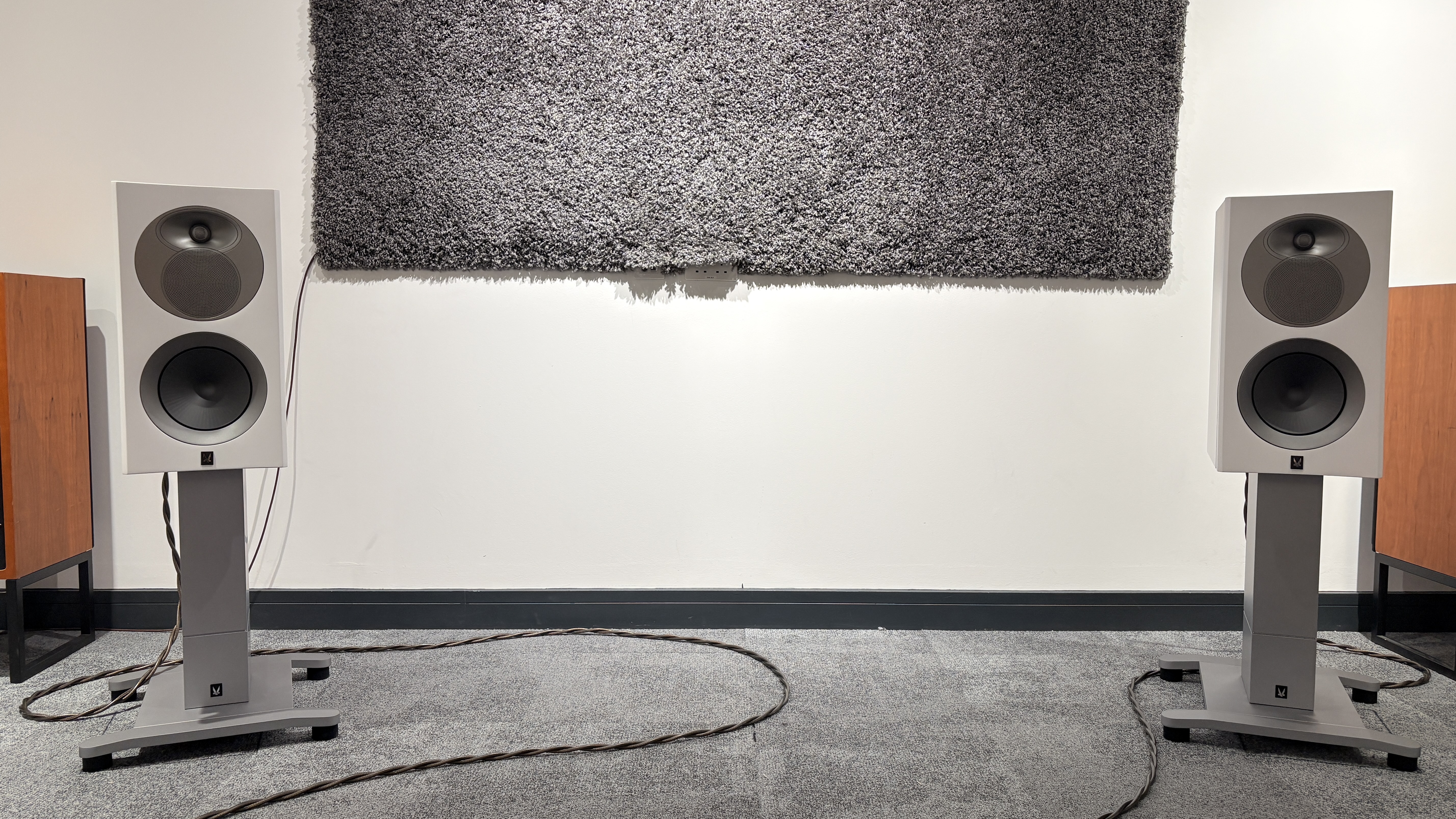 Arendal 1528 Bookshelf 8 standmount speakers on grey carpet in front of white wall 