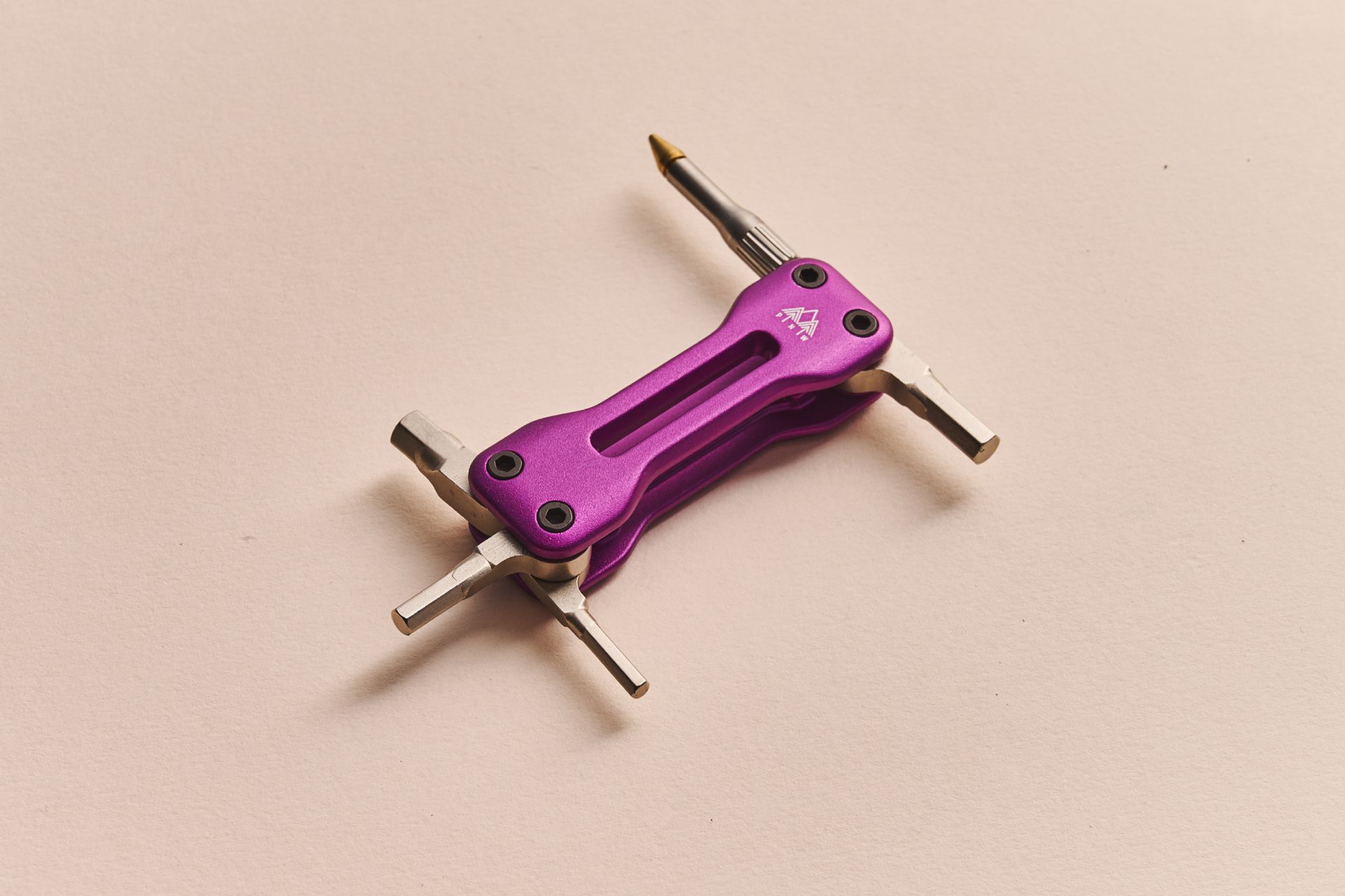 PNW Pebble bike multi-tool in purple features 5 tools on a beige background