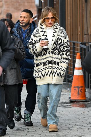 jennifer lopex wearing a fair isle sweater, a white tee shirt, jeans, and ugg boots