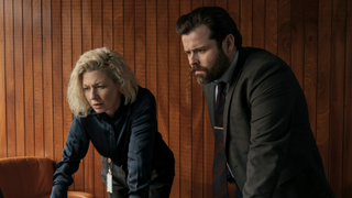Two police officers look at a computer screen