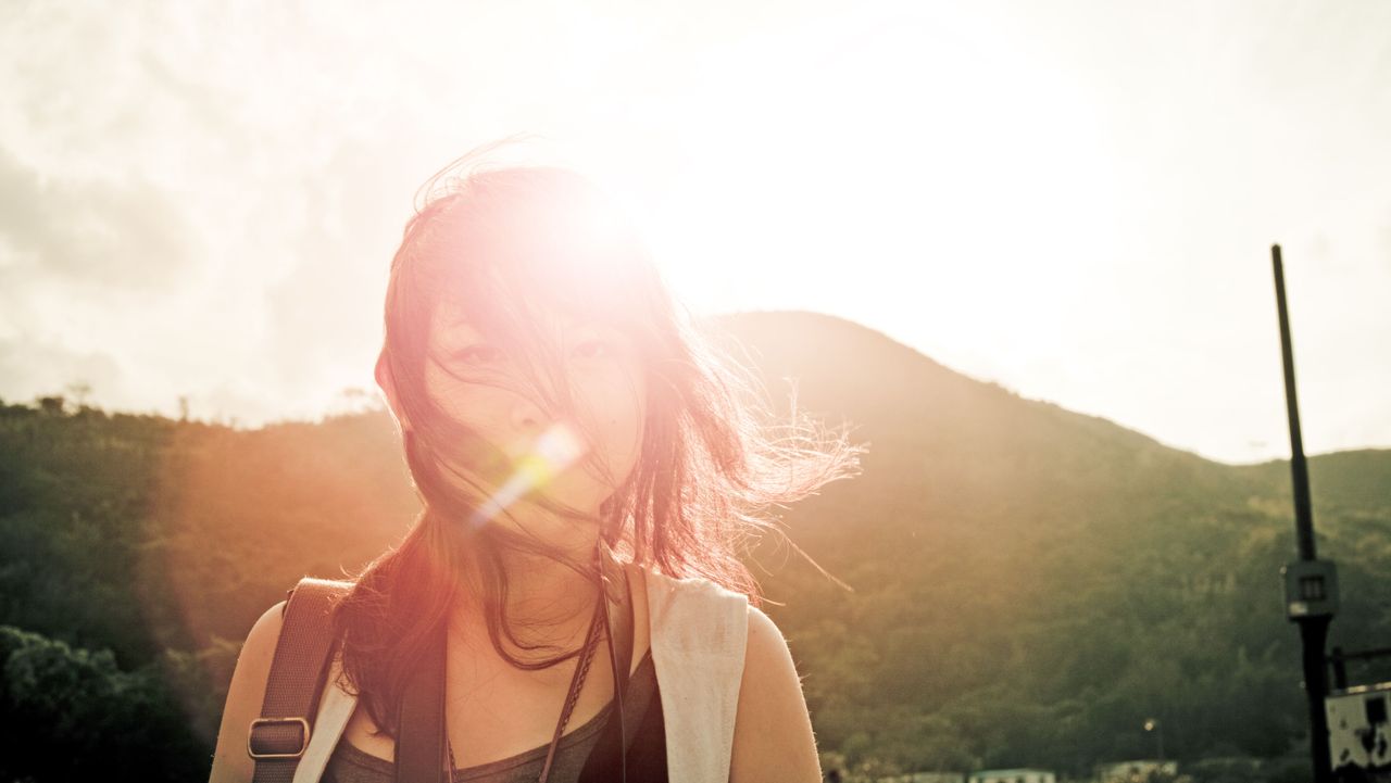 Mammal, Sun, Sunlight, Summer, Lens flare, Cap, People in nature, Light, Backlighting, Long hair, 