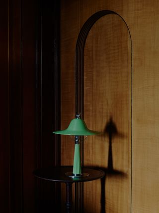The Orvington Table Lamp, made of hand-poured green resin with crafted aged silver metalwork adorned with cast bird on top