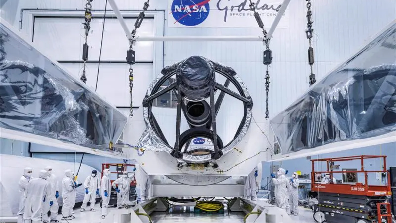 A photo of researchers stood in front of the Roman telescope's mirror