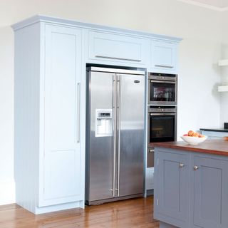 white kitchen with blue cupboard and wooden floor