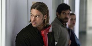 Brad Pitt's Gerry Lane looking cautiously around a corner in World War Z