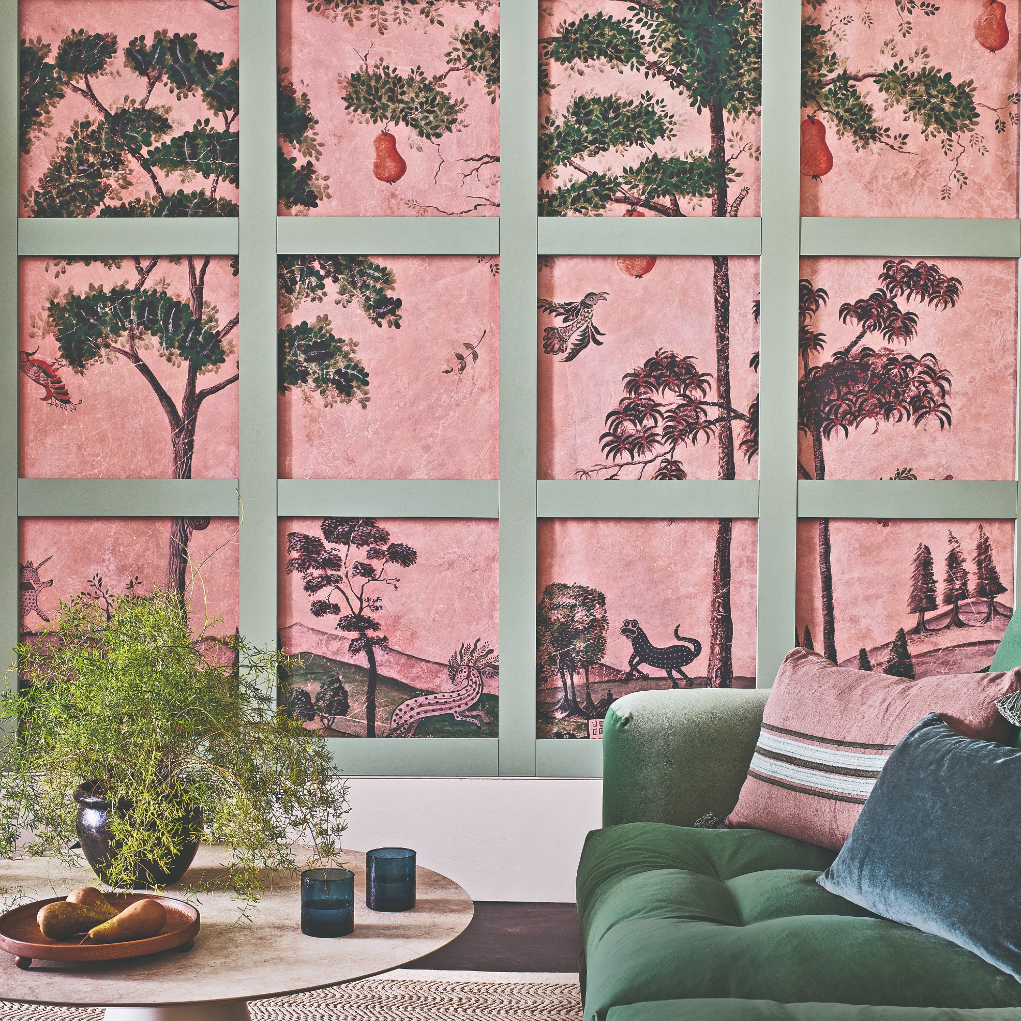A living room with a pink wall mural of a landscape with panels partly covering it