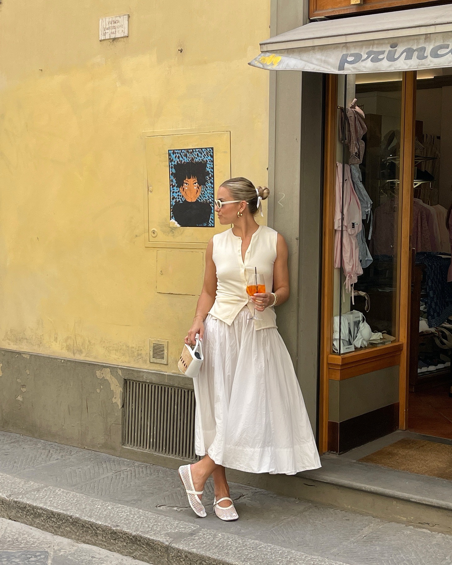 Influencer @izzydilg wears white mesh ballet flats with a white skirt and white sleeveless cardigan.