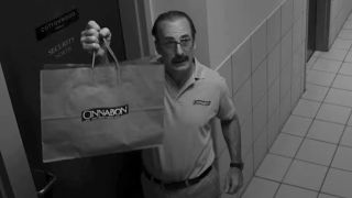 Saul as Gene holding Cinnabon bag up to camera in Better Call Saul