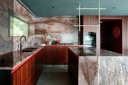 marble kitchen with red surfaces and big island