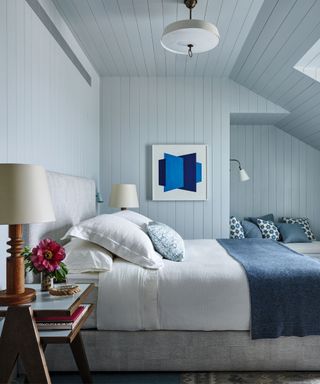 bedroom with wood paneled walls in light blue