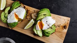 Eggs and avocado sitting on a chopping board