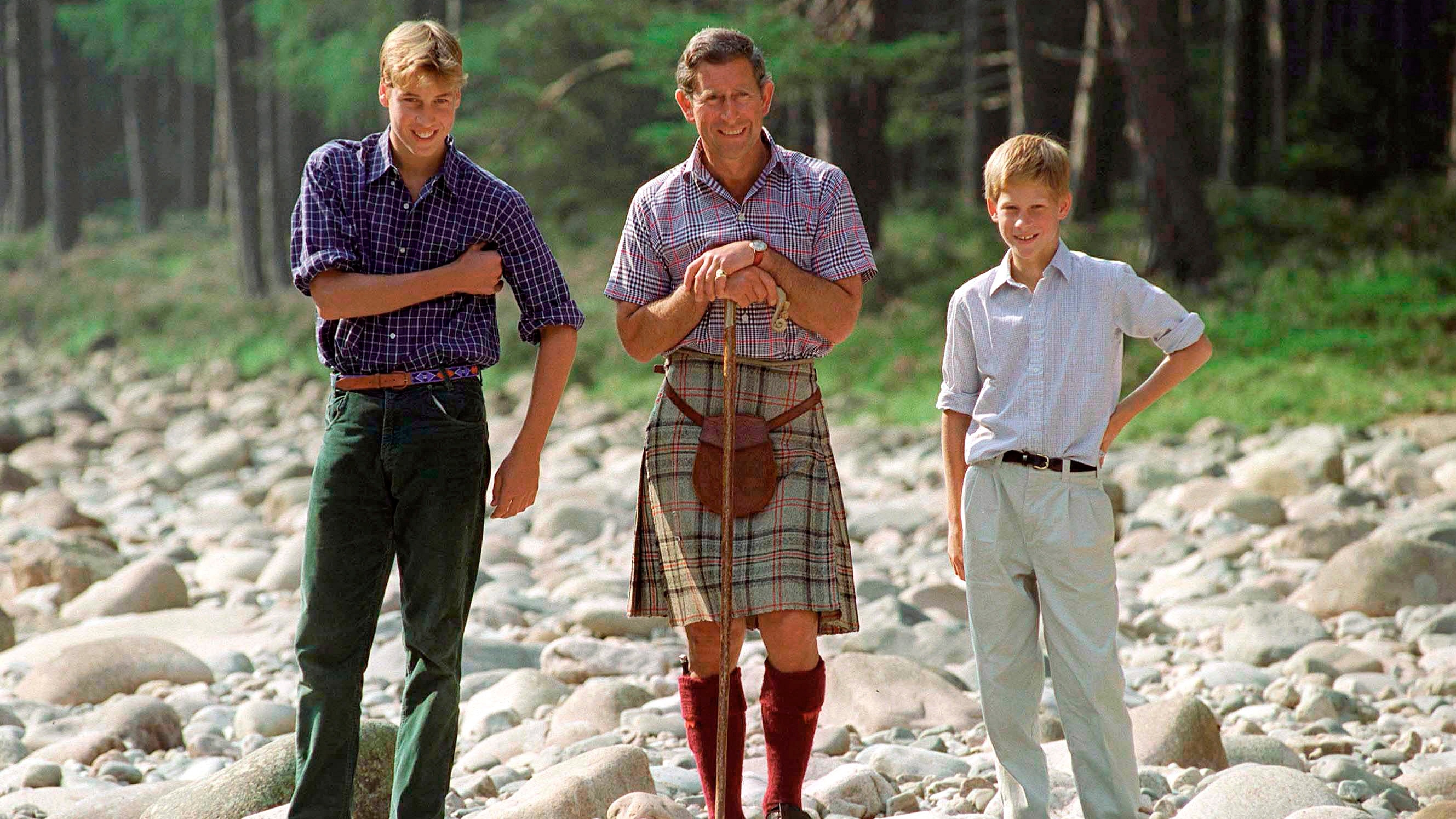 King Charles holding a walking stick, Prince William and Prince Harry at Polvier, by the River Dee, Balmoral Castle Estate