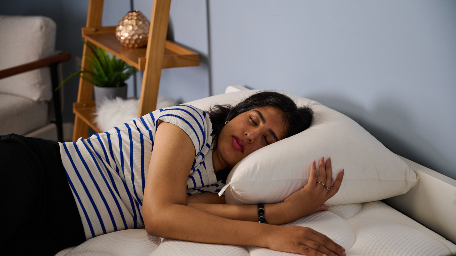 Bedding writer Becky George lying on her side testing the Norvegr Premium Collection European White Goose Down Firm Pillow