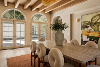 A dining room with a long, rectangle table and chairs with round backs