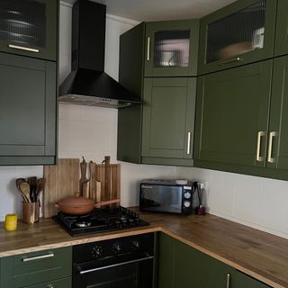 green kitchen with cooker and extractor hood
