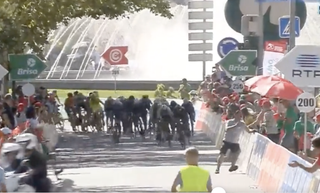 A man is seen (on right) leaping to safety as the peloton charges to finish of stage 1 at 2022 Volta a Portugal