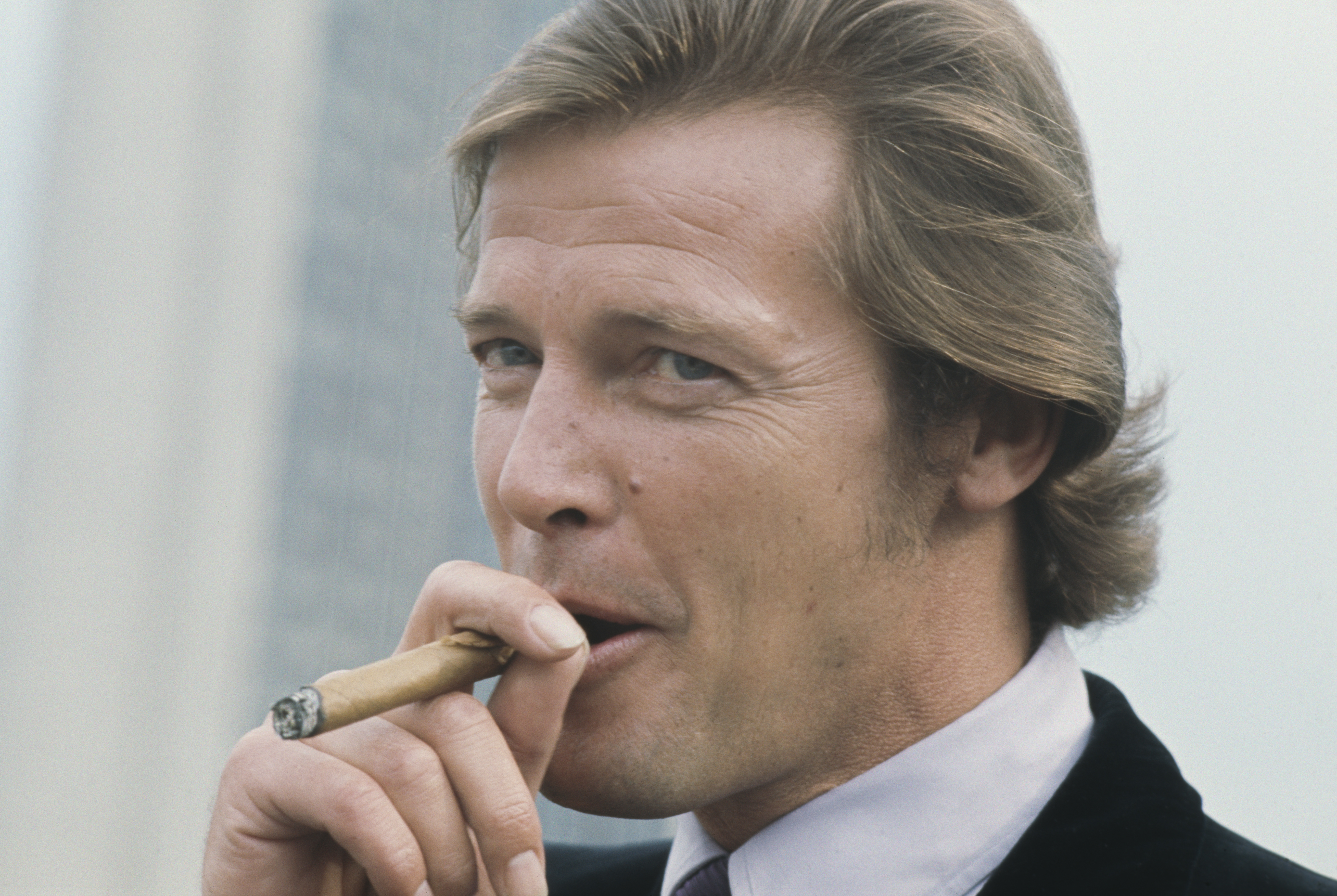 Roger Moore smoking a cigar