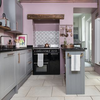 Kitchen decorated in pale pink with white tiled floor and pale grey kitchen units