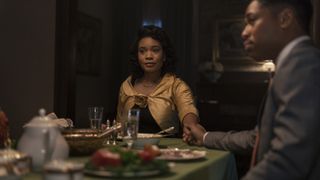 Weruche Opia and Kelvin Harrison Jr. as Coretta and Martin holding hands at a dinner table in Genius: MLK/X