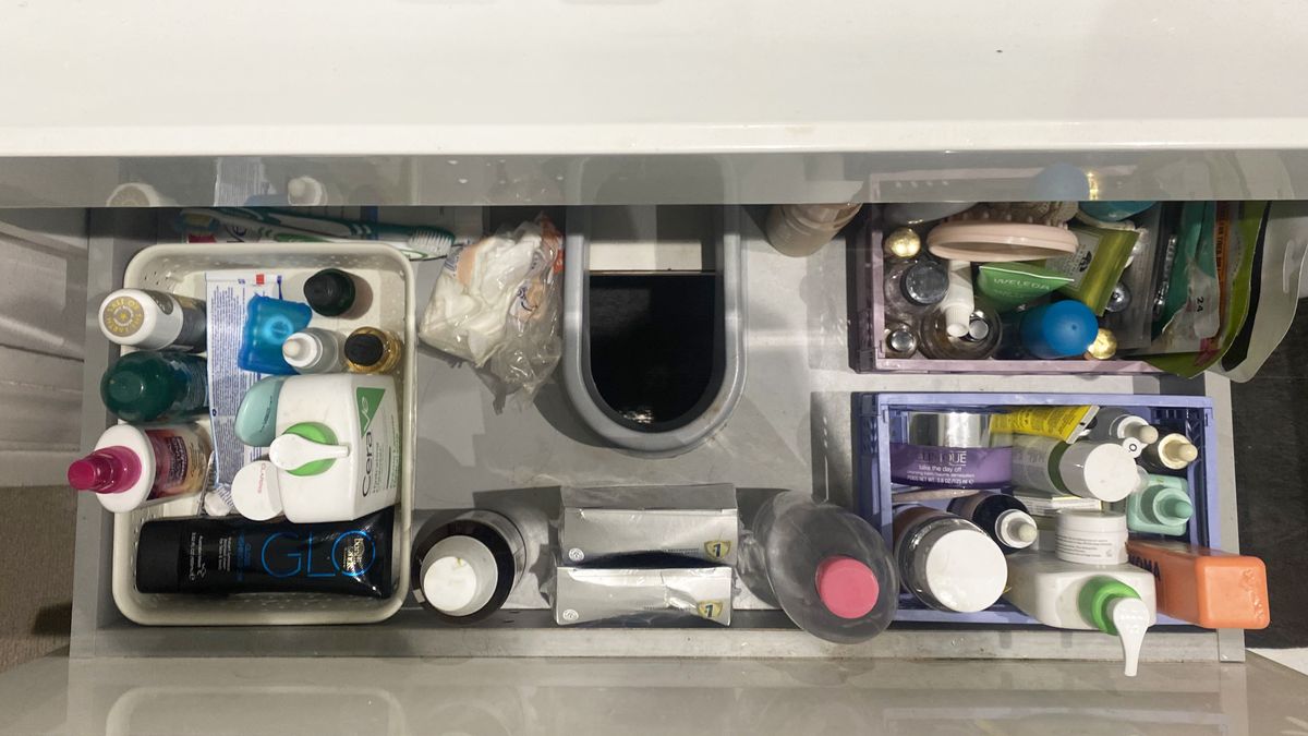 Under the sink bathroom drawer showing products nicely organized in boxes.