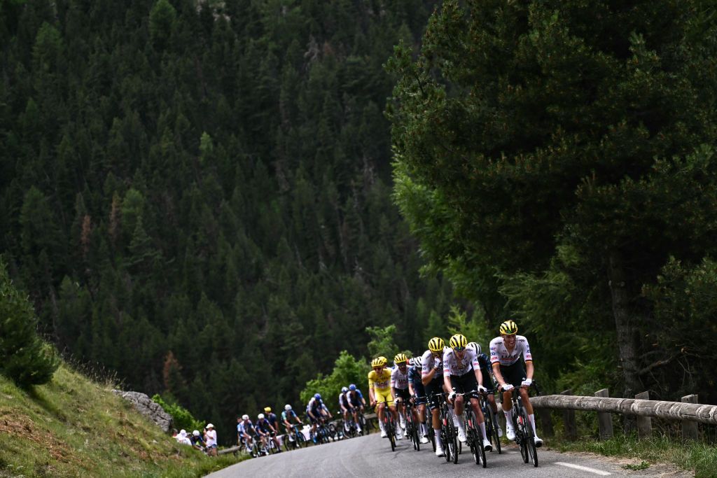 UAE Team Emirates team's German rider Nils Politt leads the pack of riders (peloton) in the ascent of the Cime de la Bonette during the 19th stage of the 111th edition of the Tour de France cycling race, 144,6 km between Embrun and Isola 2000, in the French Alps, on July 19, 2024. (Photo by Marco BERTORELLO / AFP)