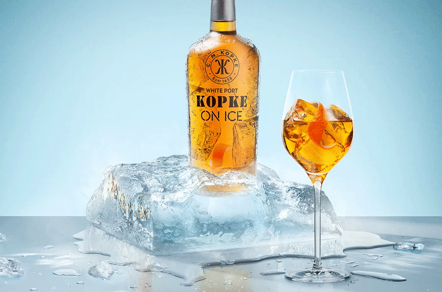 Bottle of Kopke on Ice next to a glass with the grapefizz cocktail