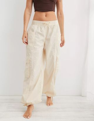 Model wearing cream parachute pants with pockets