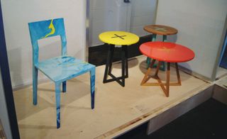 A blue chair and a trio of brightly coloured tables