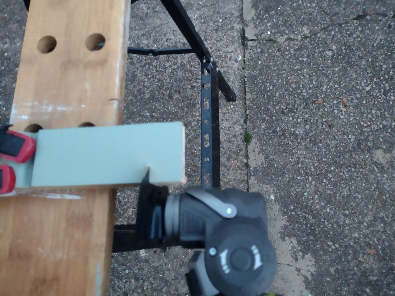 A small piece of wood in a vice being cut with a multitool