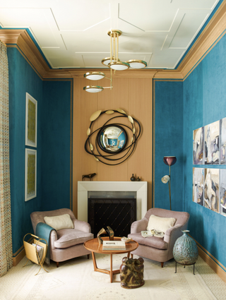 living room with blue walls and fireplace, and panelling detail in light wood