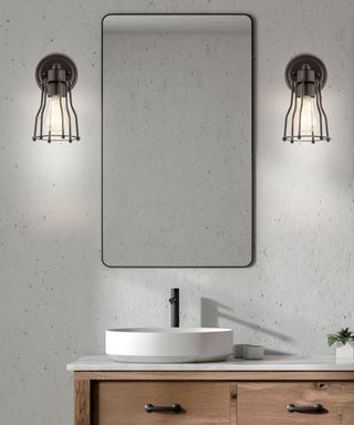 Bathroom with concrete walls, black wall lights, a black mirror, and a wooden vanity