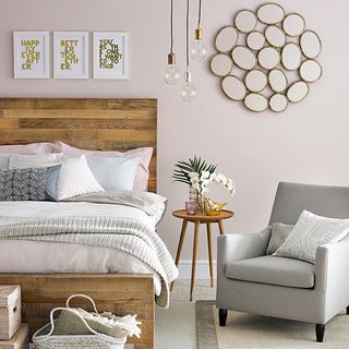 pink walled bedroom with carpet flooring and grey armchair