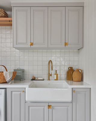 laundry room storage ideas grey cabinets and white tiles by Tiffany Leigh Design