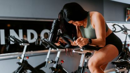 Woman riding exercise bike trying to burn calories